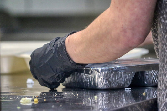 Packing up a delivery order at a restaurant in metal foil pan with lid